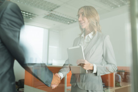 Pretty smiling business lady greeting her coworkers