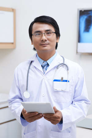 Portrait of Vietnamese doctor holding tablet computerの写真素材