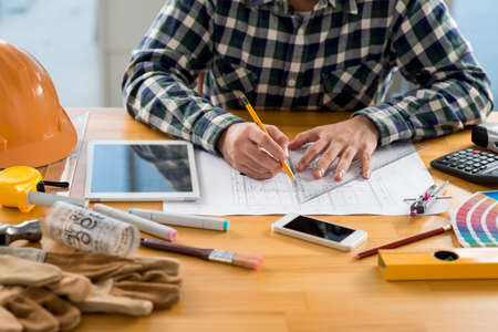 Cropped image of engineer working on plan of the buildingの写真素材