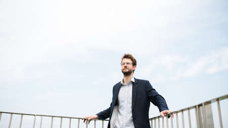 Handsome businessman standing on the roof of the skyscraperの写真素材