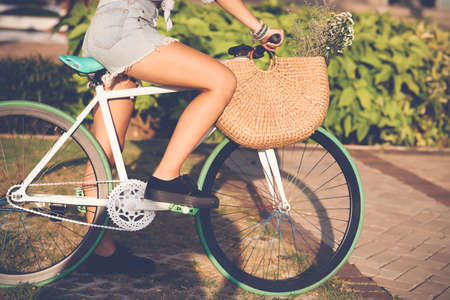Cropped image of girl in denim shorts riding bicycleの写真素材