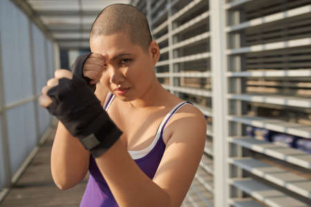 Portrait of Vietnamese bald woman in sports gloves fightingの写真素材