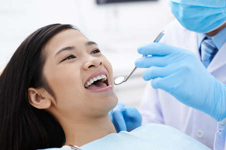 Close-up image of dentist using mouth mirror during check-upの写真素材