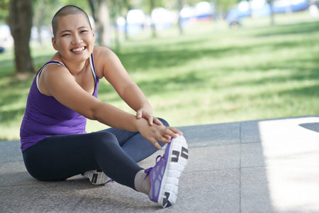 Vietnamese bald woman doing exercising outdoors