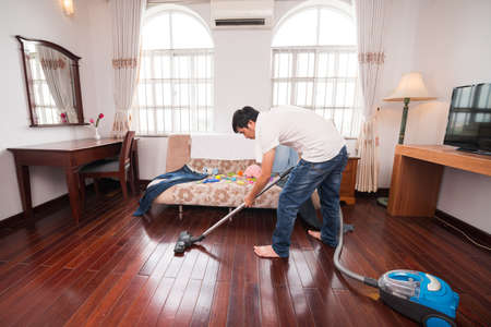 Asian househusband cleaning the roomの写真素材
