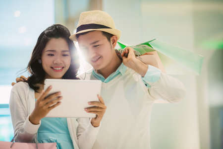 Couple using digital tablet to read information about saleの写真素材