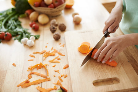 Hands of woman cutting carrot for the healthy dish