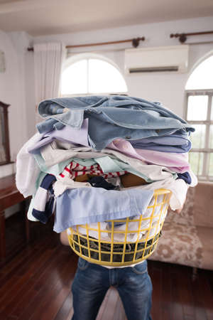 Man holding big basket of dirty clothes: laundry conceptの写真素材