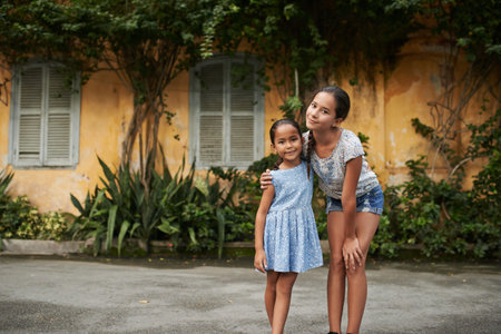 Lovely preteen girl posing with her little sisterの写真素材