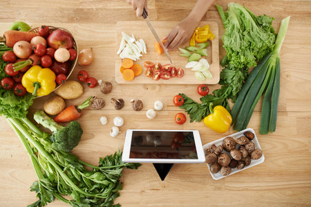 Woman cutting vegetables for the dish, view from aboveの写真素材