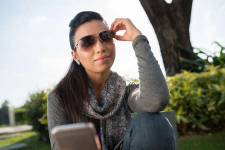 Pretty Indian woman in sunglasses taking selfieの写真素材
