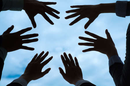 Palms of business people against the blue skyの写真素材