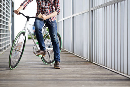 Cropped image of guy riding bicycle and listening to the musicの写真素材