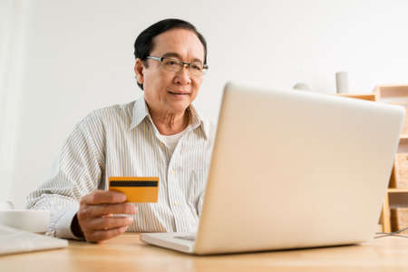 Mature Vietnamese man paying bills onlineの写真素材