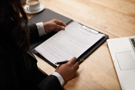 Female entrepreneur reading business contract, view over the shoulderの写真素材