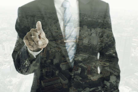 Double exposure of entrepreneur pointing at you and big cityの写真素材