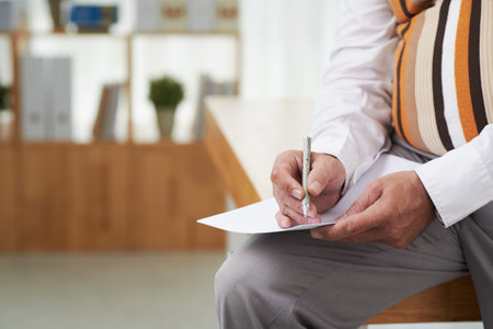Cropped image of man writing his ideas on sheet of paper