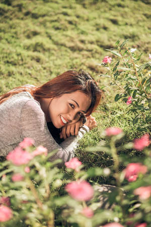 Pretty smiling woman lying on the grassの写真素材