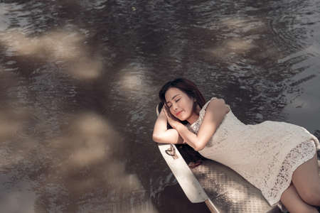 Pretty young woman sleeping in a boatの写真素材