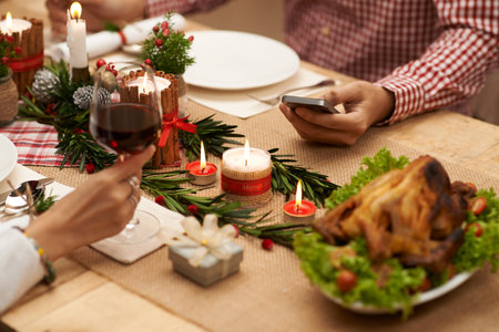 Hand of man using smartphone at the Christmas dinner