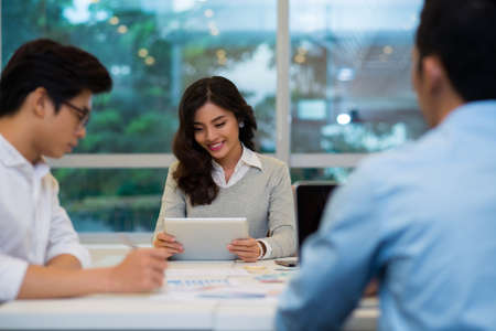 Attractive Vietnamese business lady reading something in the digital tabletの写真素材