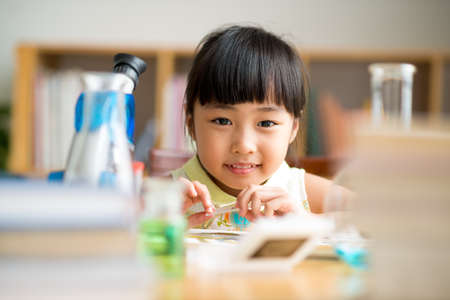 Little Asian girl having science class, focus on faceの写真素材