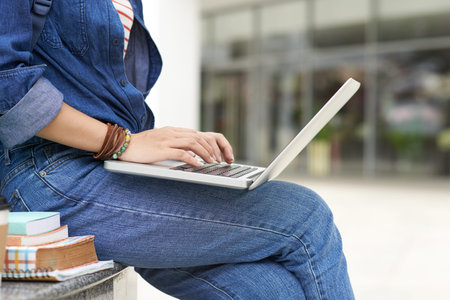 Close-up image of woman using laptop outdoors, side viewの写真素材