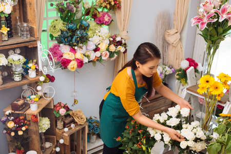 Asian young woman working in flower shopの写真素材