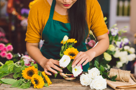 Cropped image of florist arranging flowers in the shopの写真素材