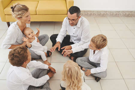Large family playing together when sitting on the floorの写真素材