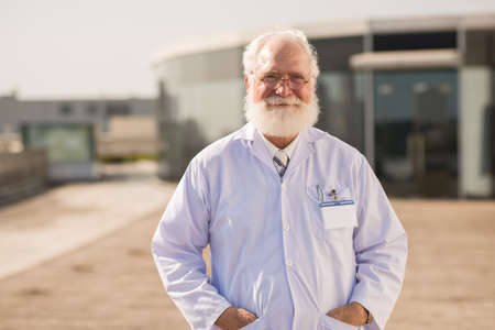 Portrait of smiling senior scientist in lab coatの写真素材