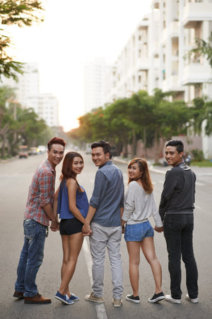 Portrait of teenage friends holding hands and smilingの写真素材