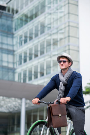 Young man going to work on bicycleの写真素材