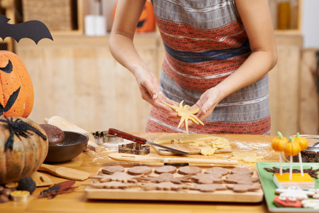 Woman making spider cookies for Halloweenの写真素材