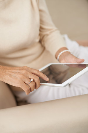 Hands of senior woman using digital tablet