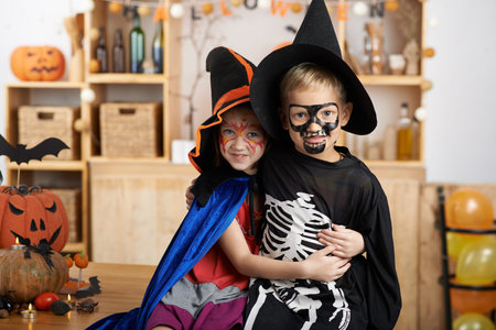 Hugging brother and sister in Halloween costumesの写真素材