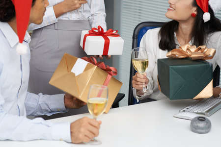 Cropped image of business people exchanging Christmas presents in the officeの写真素材