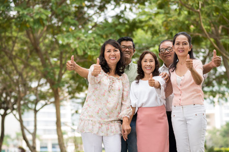 Cheerful Vietnamese senior people showing thumbs-up