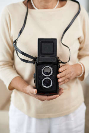 Cropped image of aged woman holding vintage photo cameraの写真素材