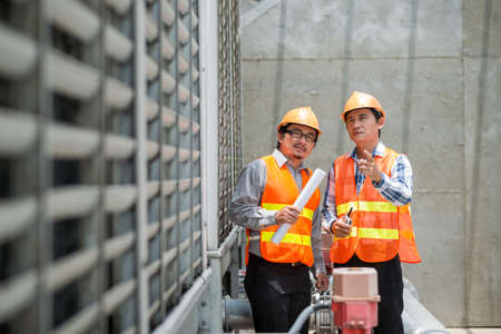 Asian construction workers examining quality of new buildingの写真素材