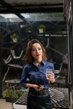 Portrait of proud Vietnamese restaurant owner with a glass of waterの写真素材