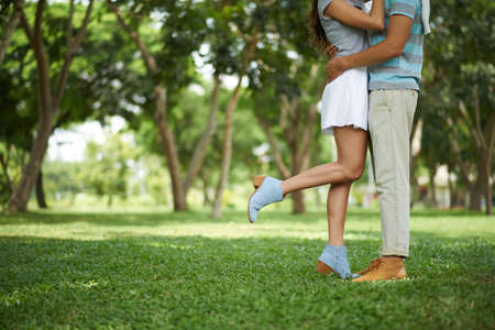 Cropped image of couple kissing in the park: love and relationship conceptの写真素材
