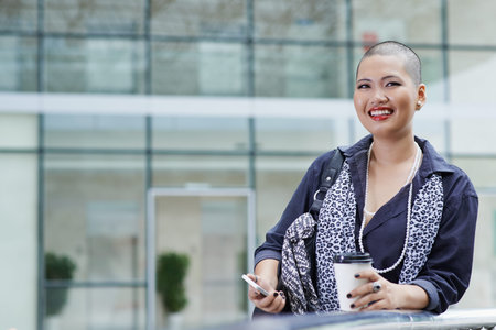 Beautiful Asian business lady with shaved hairstyle smiling and looking at the camera