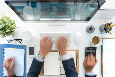 Hands of business person working at his table, blurred motionの写真素材