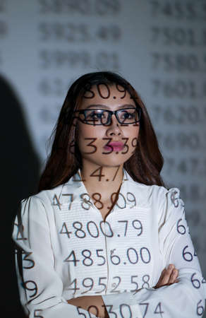 Female business broker looking at the stock exchange boardの写真素材