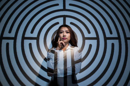 Young business lady trying to find solution to complex mazeの写真素材