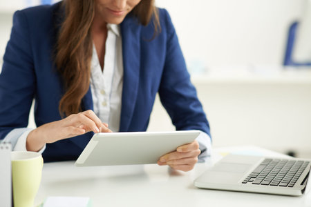 Modern business: manager using tablet computer her workplace