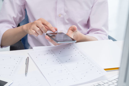 Hands of business person taking photo of financial chart with his smartphone