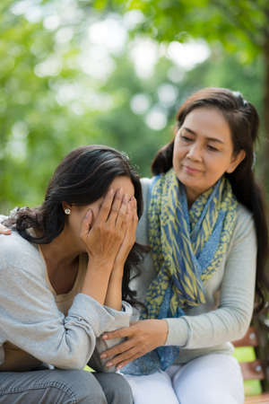 Vietnamese mature woman comforting her unhappy friendの写真素材