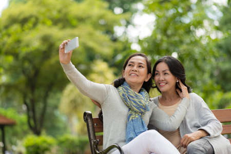 Beautiful middle-aged women taking selfie togetherの写真素材